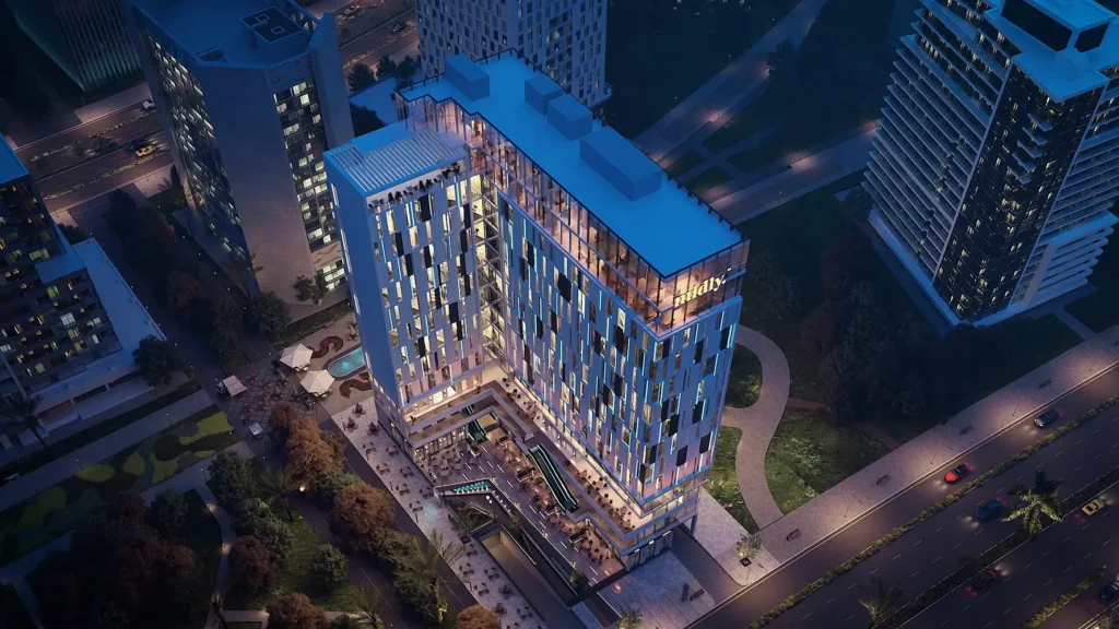 Modern high-rise building with illuminated facade in an urban setting.