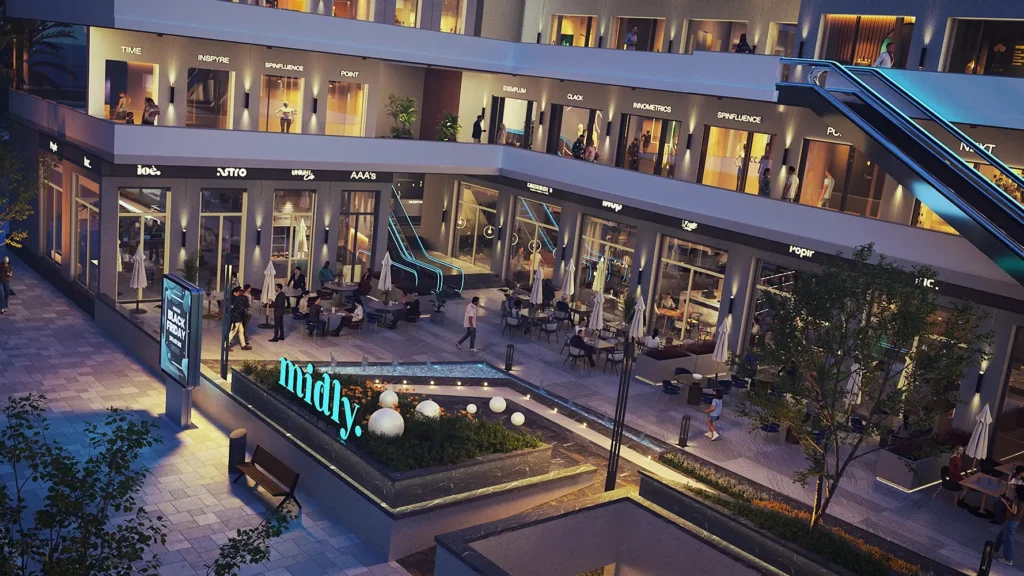 Modern shopping complex with outdoor seating and retail stores at night.